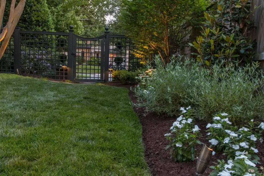 Modern, decorative fence and gate surrounded by lush plantings in Mt. Vernon
