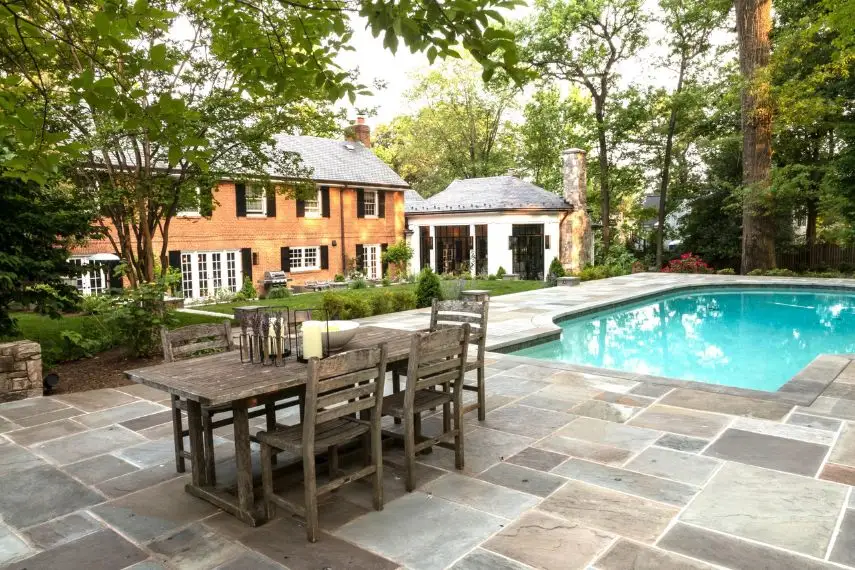 Backyard oasis with pool, cabana, and seating featuring hardscaping in Great Falls, Virginia