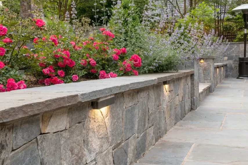 elevated planting boxes and hardscape retaining wall with accent lighting in Tysons, Virginia