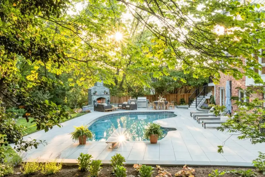 Outdoor living space with pool, patio, fireplace, and seating in Alexandria Virginia