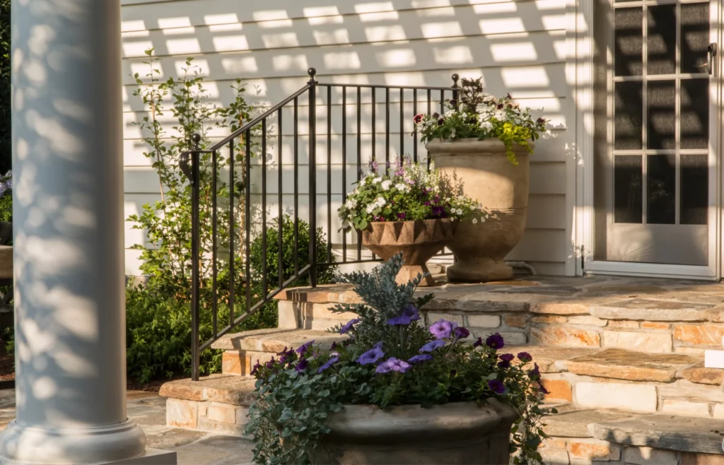 backyard porch with stairs and iron handrail